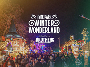 A crowd of people amongst festive stalls at Hyde Park Winter Wonderland