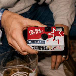 Man holding a Brothers Disposable camera 