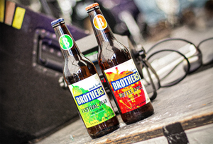 Bottle of Festival Pear and Brothers Toffee Apple on a music stage by a speaker