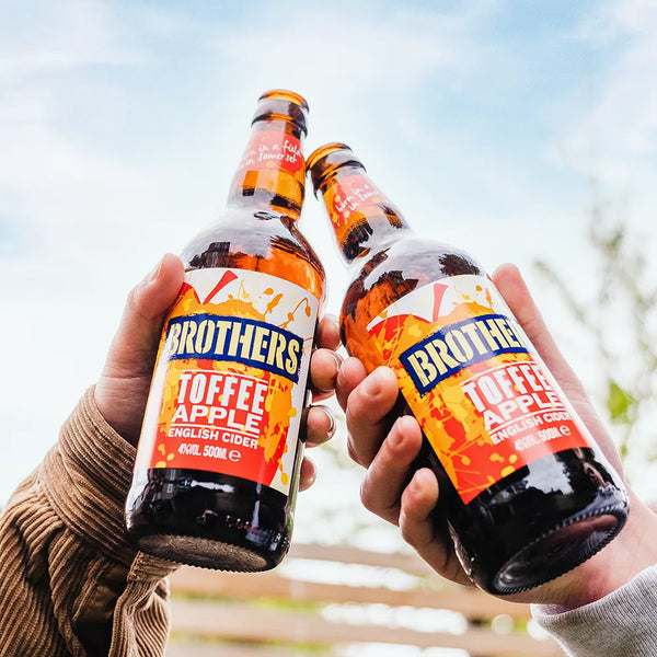 Two bottles of Brothers Toffee Apple Cider cheers with blue sky